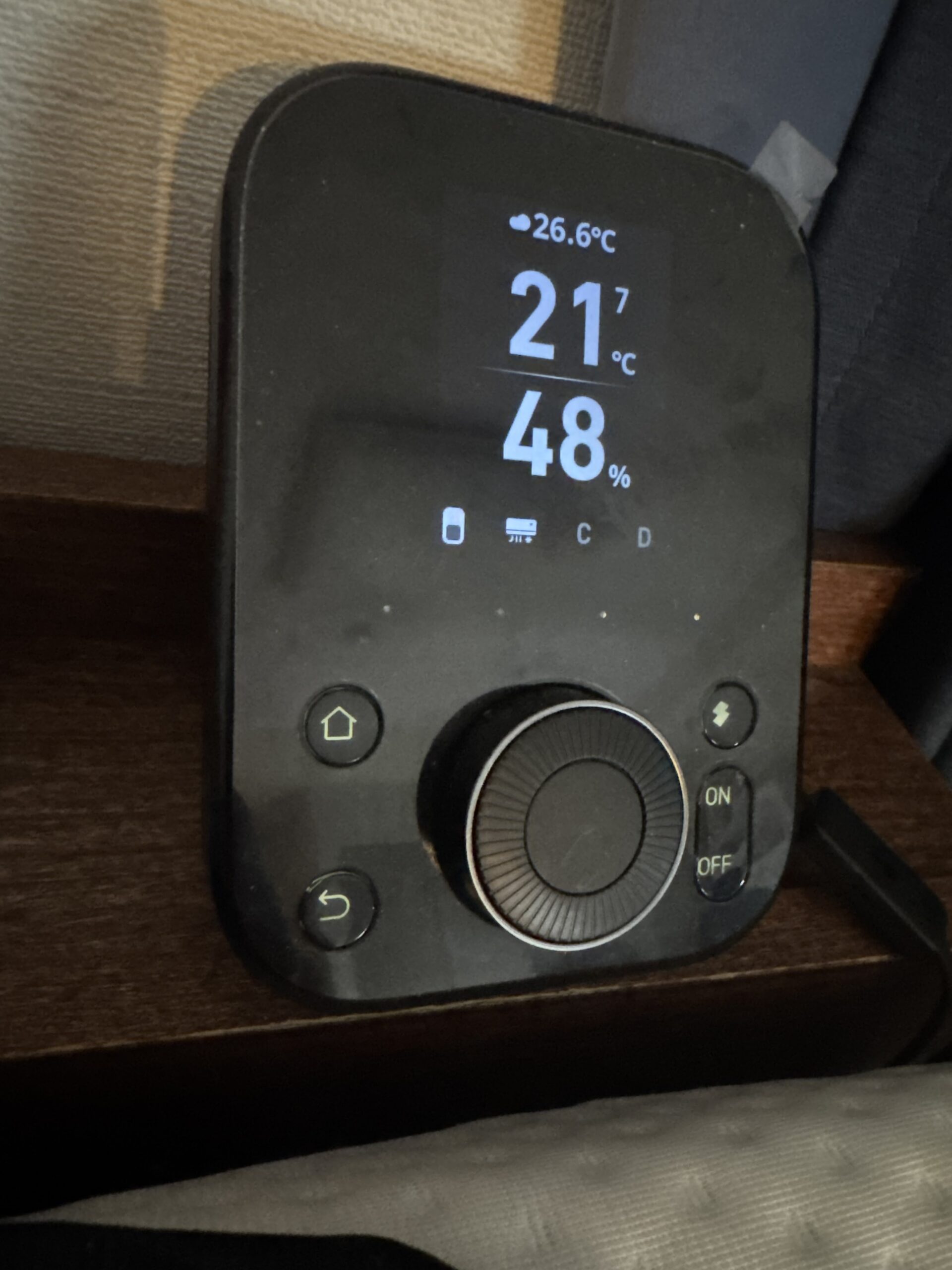 SwitchBot ハブ2本体。ディスプレイに室温21℃・湿度48%が表示されている。ON/OFFボタンとダイヤル付き